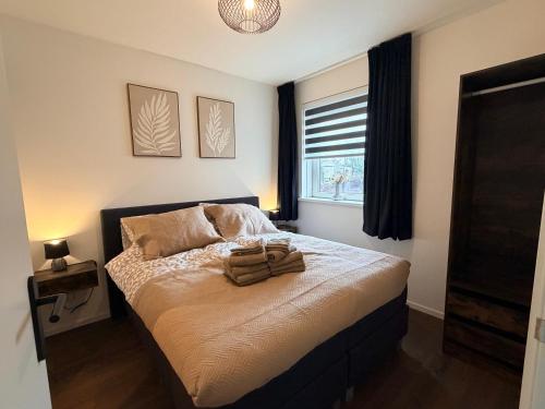 a bedroom with a bed with two towels on it at Appartement Ocean Breeze Nes Ameland in Nes