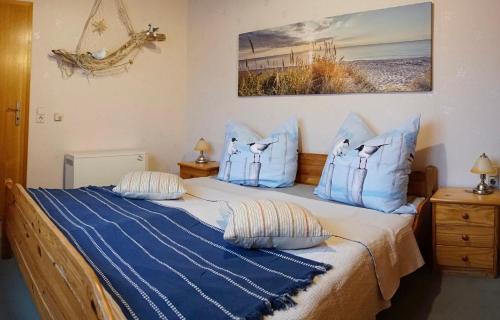 a bedroom with two beds with blue and white pillows at Haus Feldblick auf Rügen in Garz