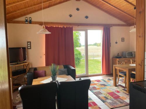 a living room with a table and a large window at Haus Feldblick auf Rügen in Garz