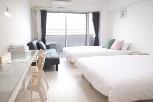 a hotel room with two beds and a couch at House L in Shinjuku in Tokyo