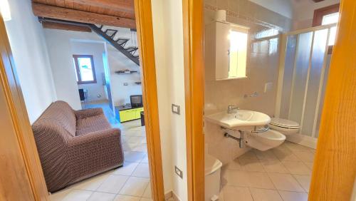 a bathroom with a toilet and a sink and a chair at La Nocina in Raggio