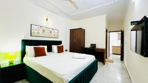 a bedroom with a bed and a television in it at Olive Serviced Apartments - Central Delhi in New Delhi