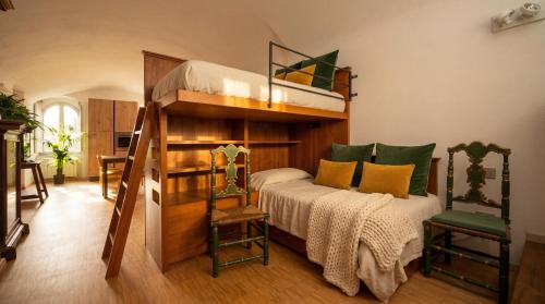 a bedroom with a bunk bed and two chairs at Edoardo Historic House in Gubbio