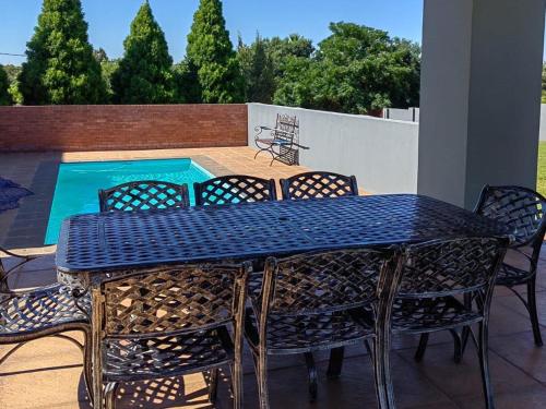 a blue table and chairs on a patio with a pool at 2nd Cozy Corner in Highlands
