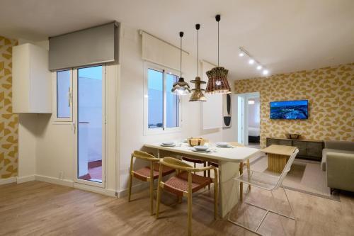 a kitchen and living room with a table and chairs at MOON Apartments in Seville