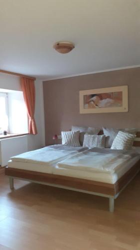 a large bed in a bedroom with a window at Ferienhaus-Feinen in Lierfeld