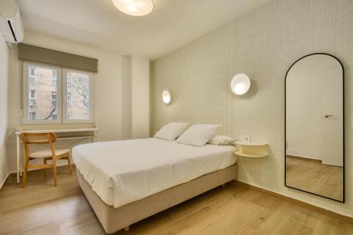 a bedroom with a large bed and a mirror at MOON Apartments in Seville