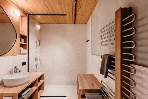 un baño con lavabo y ducha en Hotel Adler, en Au im Bregenzerwald