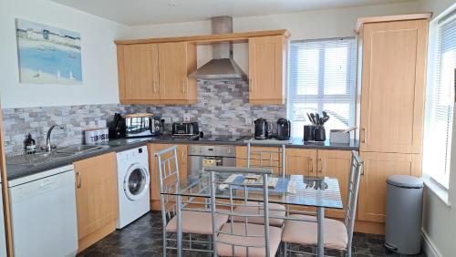 a kitchen with a sink and a table with chairs at Rock Quay in Killyleagh