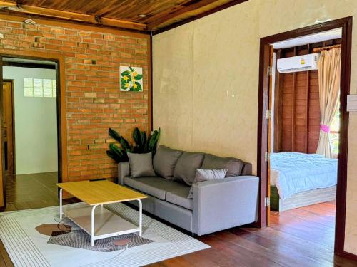 a living room with a couch and a table at Cozy Beach House , 5 mn from the Sea -Self Check in in Ban Laem Sai