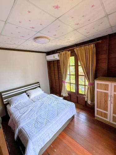 a bedroom with a bed with a blue comforter at Cozy Beach House , 5 mn from the Sea -Self Check in in Ban Laem Sai