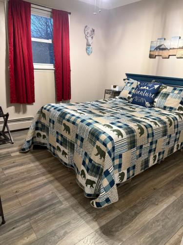a bedroom with a bed with a blue and white comforter at Roscoe Cabin Pet friendly in Roscoe
