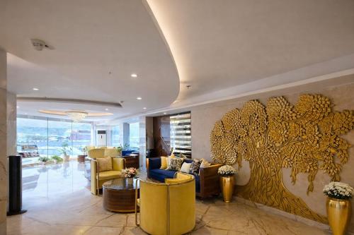 a living room with a large gold painting on the wall at Hotel Ramhan Palace in New Delhi