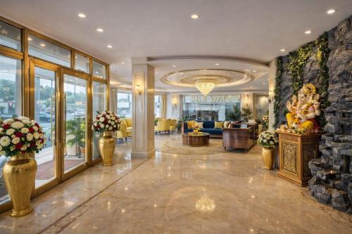 a lobby of a hotel with flowers in vases at Hotel Ramhan Palace in New Delhi