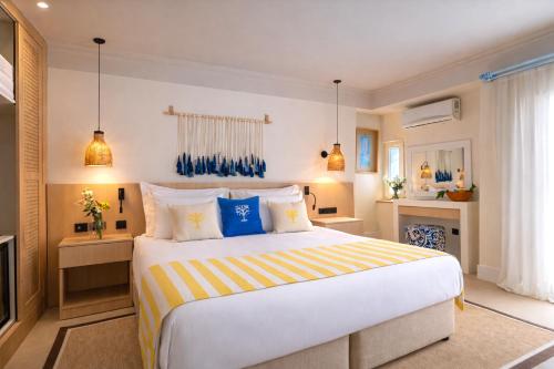 a bedroom with a large bed with blue and yellow pillows at Başka Resort Bodrum in Bodrum City