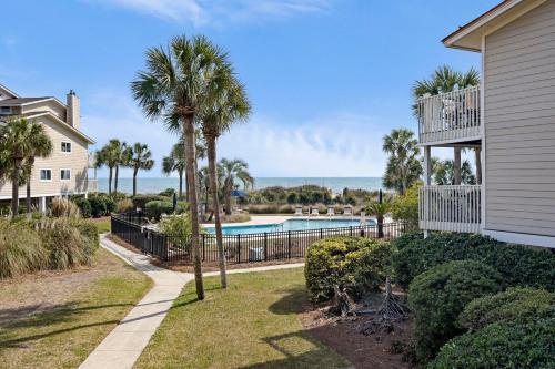 a house with a swimming pool and palm trees at SG8A: 8A Seagrove Villa in Isle of Palms