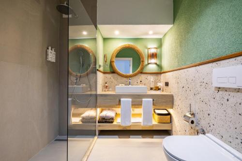 a bathroom with a sink and two mirrors at Başka Resort Bodrum in Bodrum City