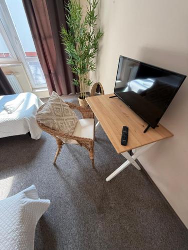 a room with a television on a table with a chair at Hotel Aqua Żyrardów in Żyrardów