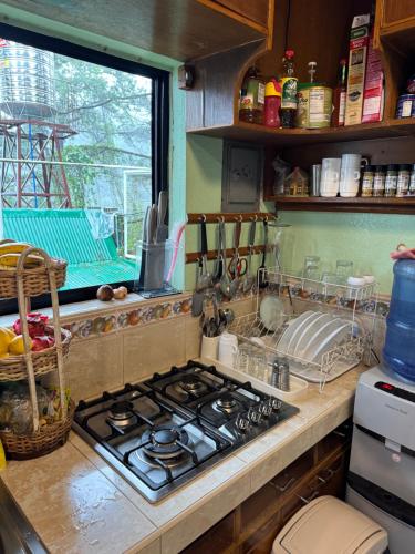 a kitchen with a stove and a sink and a window at Odara Pines Garden The Ridge House 1BR in Baguio