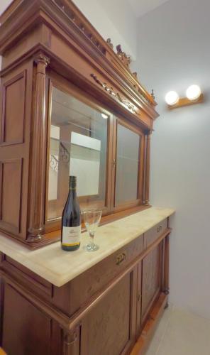 a bottle of wine and a wine glass on a cabinet at Ink Hotels Phos in Rethymno