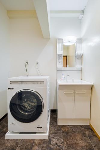 a washing machine in a kitchen with a sink at AoiResidence別邸葵 in Nagoya