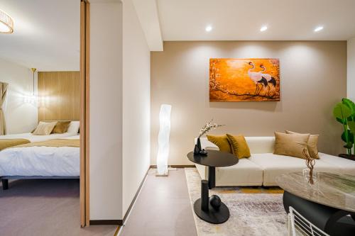 a living room with a bed and a couch at AoiResidence別邸葵 in Nagoya