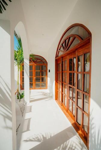 an open hallway with wooden doors and windows at Villa Charlotte in Selong Belanak