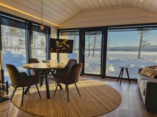 a living room with a table and chairs and a couch at Palojärven Lomakeskus in Sonka