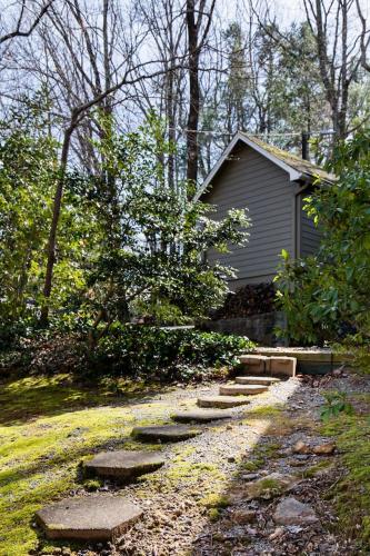 a garden with a path leading to a house at The Forest Door - Studio Suite in Stone Cottage in Tryon