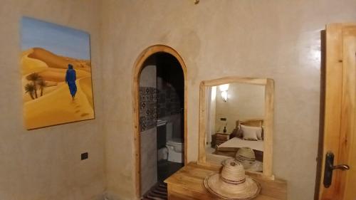 a room with a mirror and a bedroom with a bed at La Colline Verte Dar Ait El Abass in Ouarzazate