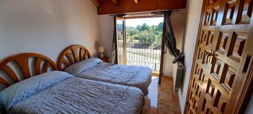 a bedroom with a bed and a large window at Apartamentos Turísticos San Cristóbal by Bossh! Hotels in Cuenca