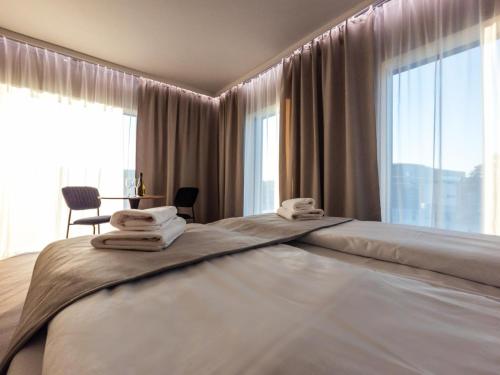 a bedroom with a large bed with towels on it at Piano Property Rental Wrocław in Wrocław