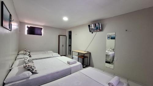 a white room with two beds and a mirror at Canto da Duna Hotel in Barreirinhas