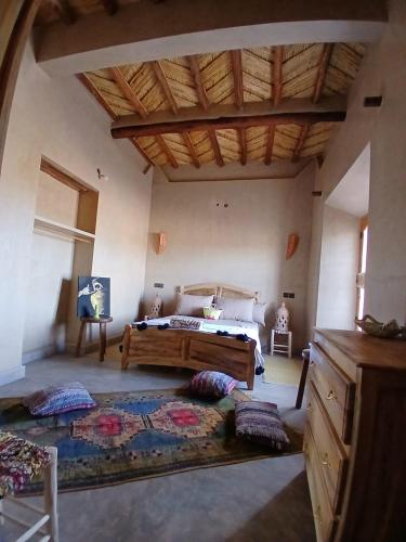 a bedroom with a bed with pillows on the floor at La Colline Verte Dar Ait El Abass in Ouarzazate