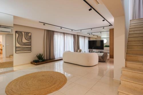 a living room with a white couch and a television at Anemos Luxury Grand Resort in Georgioupolis