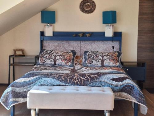 a bedroom with a large bed with a blue headboard at Villa Helena in Nowe Warpno