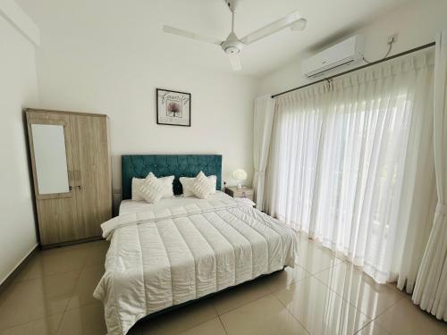a bedroom with a large bed and a window at Santorini VIP Apartment Negombo in Negombo