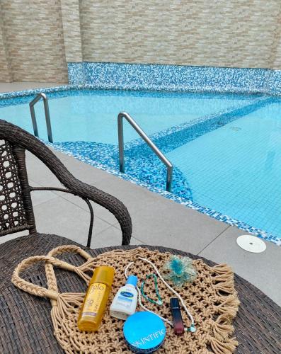 a wicker chair sitting next to a swimming pool at Thyme Residence The VAs Nest Near Anjo World Free Pool and Gym in Minglanilla