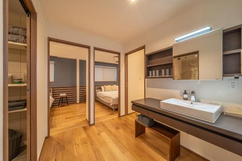 a bathroom with a sink and a bedroom at LAGUNA OKINAWA Beachfront YAKA in Kin