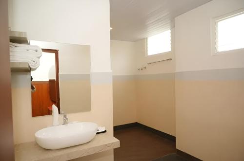 a bathroom with a white sink and a mirror at Hotel Orcella in Tirupati