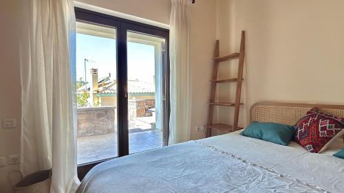 a bedroom with a bed and a large window at The Jasmine Hill in Aegenitissa