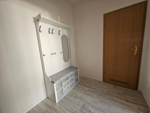 a dressing room with a mirror and a wooden door at Siggis Apart-Pension in Ostseebad Sellin
