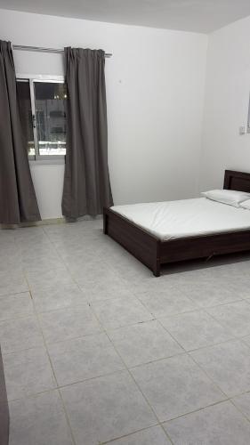 a bedroom with a bed and a window at Happy House in Al Ain