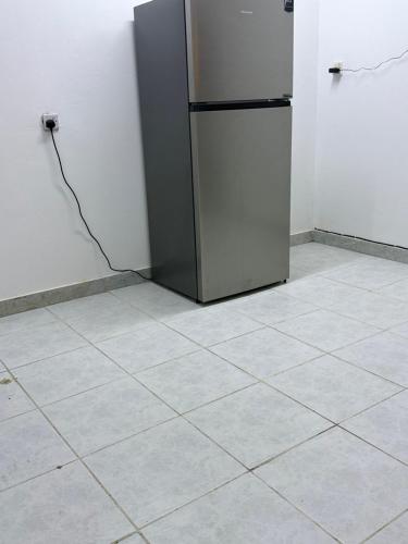 a refrigerator in a room with a tile floor at Happy House in Al Ain