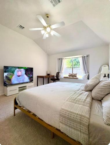 a bedroom with a large bed and a flat screen tv at 3BR-2 BA Cozy Hub Katy - Close to Cypress in Katy