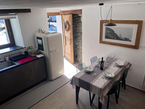 a kitchen with a dining table and a refrigerator at Little Wild House in Saint Vincent