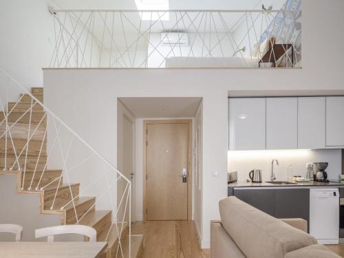 a living room and kitchen with a staircase in a house at LSA Santos by Numa in Lisbon
