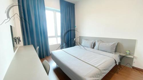 a bedroom with a bed with blue curtains and a window at The Moonlight Valley Sri Indah in Sandakan