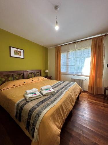 a bedroom with a bed with two towels on it at Hosteria Miyazato Inn in El Calafate
