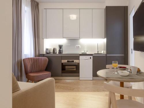a kitchen and living room with a table and chairs at LSA Santos by Numa in Lisbon